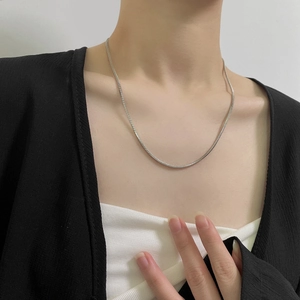 Collier chaîne serpent carrée argentée minimaliste porté par un mannequin de mode