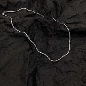 Collier maille serpent argenté minimaliste avec fermoir mousqueton sur fond noir