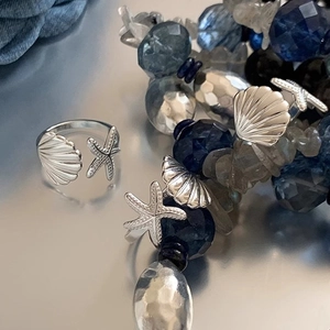 Vista macro di dettagli con conchiglia e stella marina su anello regolabile stile oceano