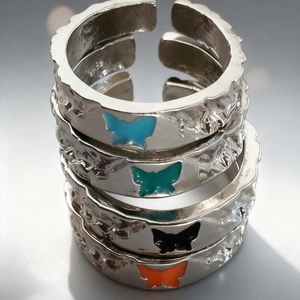 Set of four butterfly rings with hammered metal texture and adjustable silver bands