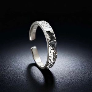 Macro detail of silver adjustable ring featuring hand-hammered texture on black background