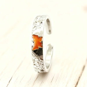 Detail of silver hammered texture ring featuring a vibrant orange butterfly charm