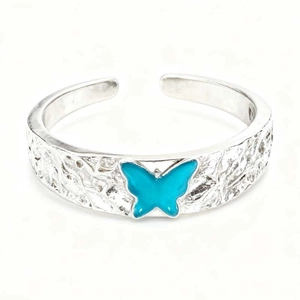 Detail of silver branch texture ring with vibrant blue butterfly enamel decoration