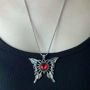 Primer plano de un collar de mariposa gótica con colgante de ojo rojo en cadena de bolas de plata