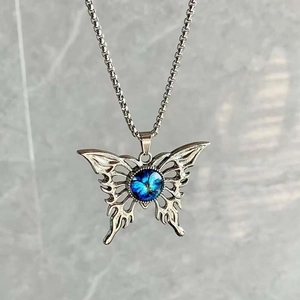 Detalle del colgante mariposa gótica de acero inoxidable con piedra azul de ojo turco
