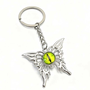 Detalle de llavero mariposa gótica con ojo de malvado verde y diseño de llama calada
