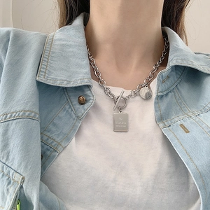 Dettaglio della collana con fibbia OT argento e ciondoli incisi Grace e Love