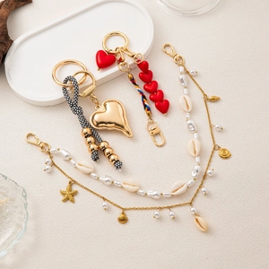 Elegant gold heart keychain and ocean-themed bag charms with pearls and sea stars