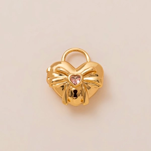 Detailoverzicht van 18K vergulde hartvormige hanger met roze steen en strikje