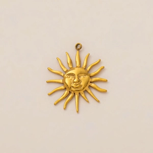 Detalle macro del colgante de cara de sol bañada en oro de 18K con rayos solares radiantes