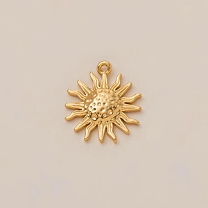 Detalle de colgante de sol chapado en oro de 18K con rayos ondulados y acabado pulido