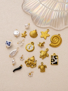 Details von 18K vergoldeten Meeresanhängern wie Muscheln, Schildkröten und Seesternen
