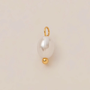 Vista macro de colgante de perla blanca ovalada con anillo chapado en oro 18K y detalle