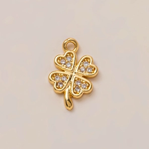 Dettaglio macro del ciondolo a quadrifoglio placcato oro 18K con micro cristalli
