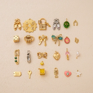 Collection of 23 gold-plated jewelry pendants featuring ballet shoes, stars and hearts