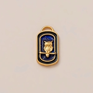 Dettaglio del ciondolo a gufo placcato oro 18K con effetto cielo stellato blu glitter