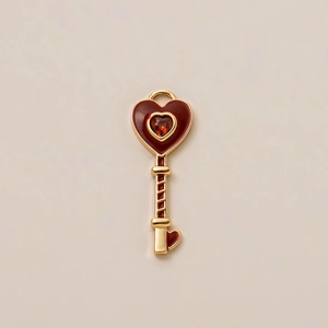 Detailed view of vintage heart key pendant with red enamel and gold-plated finish