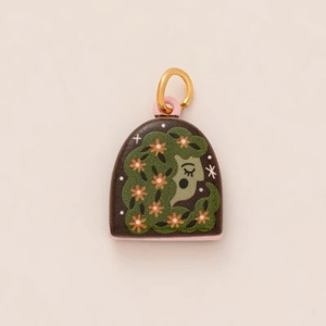 Detail of handmade 14K gold enamel pendant featuring a floral woman illustration