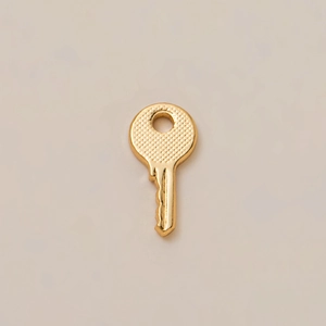 Minimalist golden key pendant in 18K plated copper with textured non-slip handle