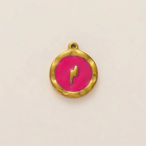 Detalle macro del colgante redondo dorado con esmalte rosa y símbolo de rayo en relieve