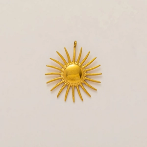 Detalle macro del colgante de sol de acero bañado en oro 18K con domo central liso