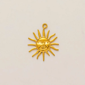 Detalle del colgante de sol bañado en oro de 18K con rasgos faciales y rayos solares