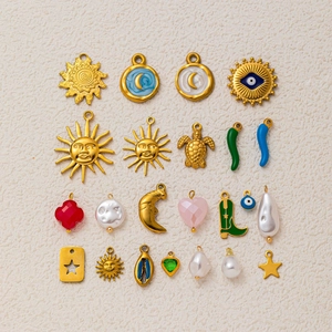 Detalle de colección de dijes bañados en oro con motivos de ojo turco y el sol