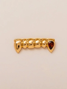 Macro-opname van 18K vergulde hiphop grillz met vampiertanden en een rode zirkoonsteen