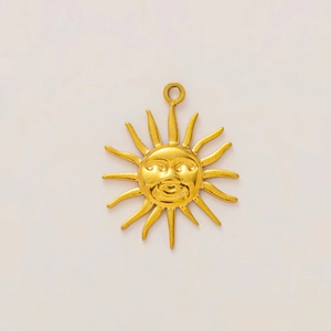 Detalle de colgante de sol bañado en oro de 18K con relieve para creación de joyería artesanal