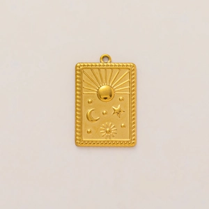 Macro detail of 18K gold-plated rectangular charm with sun and moon relief patterns