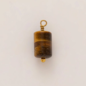 Macro detail of cylinder tiger eye stone pendant with gold wire-wrapped loop and bead