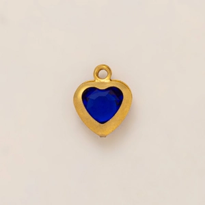 Dettaglio di un ciondolo a cuore in cristallo blu intenso con placcatura in oro