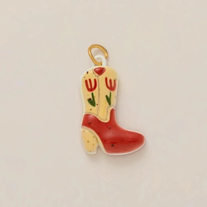 Dettaglio di un ciondolo a stivale da cowboy in ceramica con motivi di tulipani e cuori