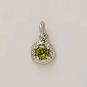 Macro shot of a silver pendant with a round green zircon in a vintage filigree setting