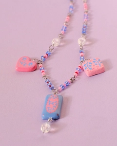 Detail of beaded necklace with floral ceramic pendants in pastel pink and blue