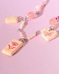 Macro shot of 18K gold plated bead bracelet with pink heart and floral pendants