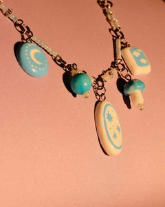 Macro shot of 18K gold plated necklace with ceramic star, moon, and mushroom charms