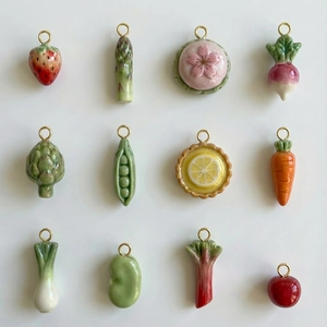 Detail showing 12 miniature vegetable pendants with polished gold-plated metal loops