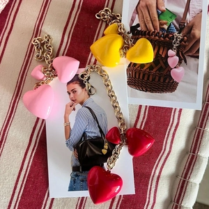 Detail of colorful resin heart charms and gold metal chains on various fashion accessories