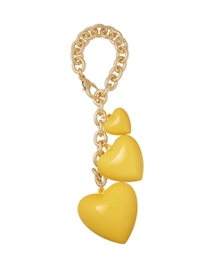 Close-up of golden metal chain with three yellow resin heart pendants of varied sizes