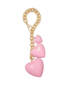 Close-up of golden chain keychain with three polished pink heart-shaped pendants