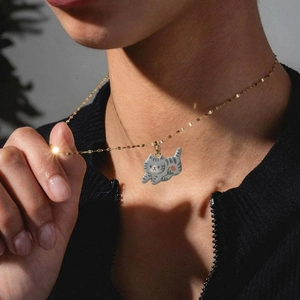 Charming golden chain necklace with a cute grey tabby cat pendant and floral detail