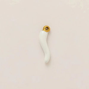 Macro detail of white Italian Corno charm with 18k gold plated stainless steel ring