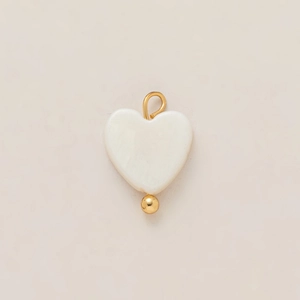 Close-up of heart-shaped shell pendant with 18k gold plated bail and small bead