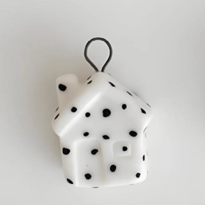 Macro detail of a 18K gold plated stainless steel house pendant with black polka dots
