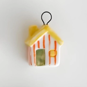 Detail shot of a yellow and orange house pendant charm with a vacuum 18K gold plated loop