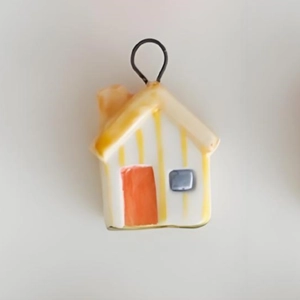 Detail of colorful ceramic house pendant with 18K gold plated ring and striped roof