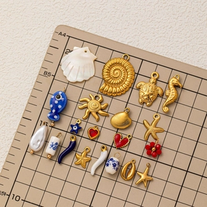 Nautical sea life pendants in 18k gold plated stainless steel on a professional grid mat