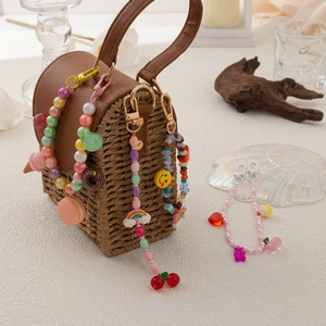 Bunte Perlen-Taschenanhänger mit Macaron- und Donut-Motiven an einer Flechttasche