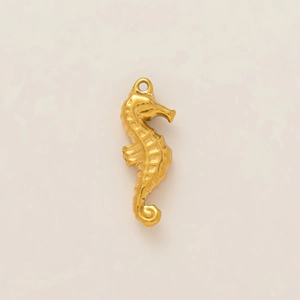 Detailed close-up of a 18k gold-plated seahorse pendant with intricate textured relief